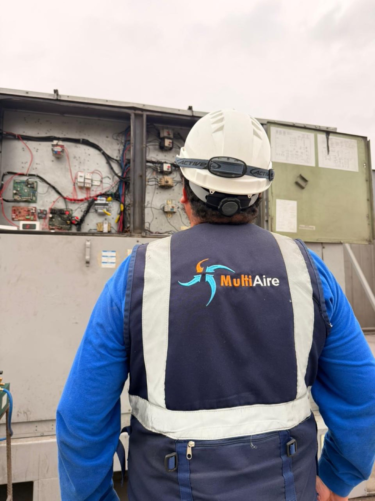 Técnico de MultiAire con uniforme e identificación de la empresa en una instalación